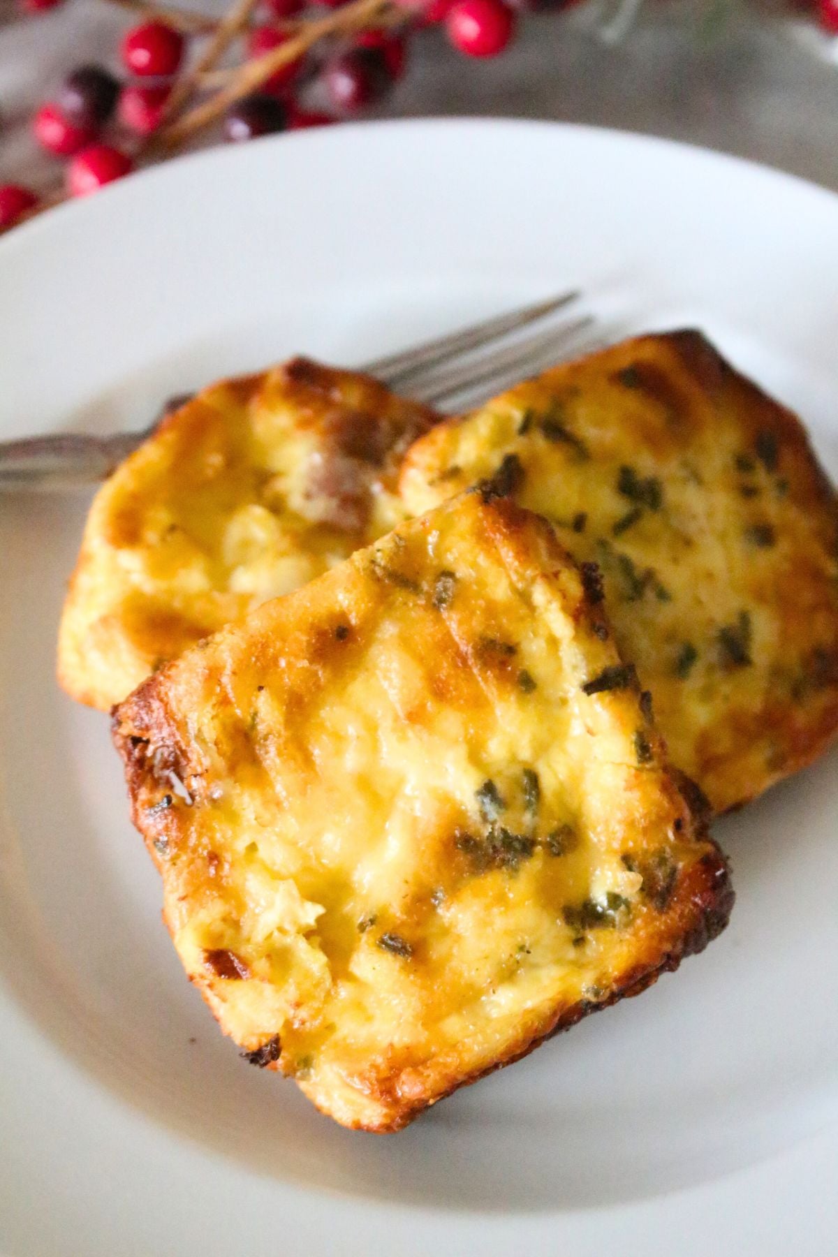 Close up of 3 homemade copycat starbucks potato cheddar and chive bakes on a white plate.