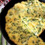 Finished vegetable frittata being served in a cast-iron skillet