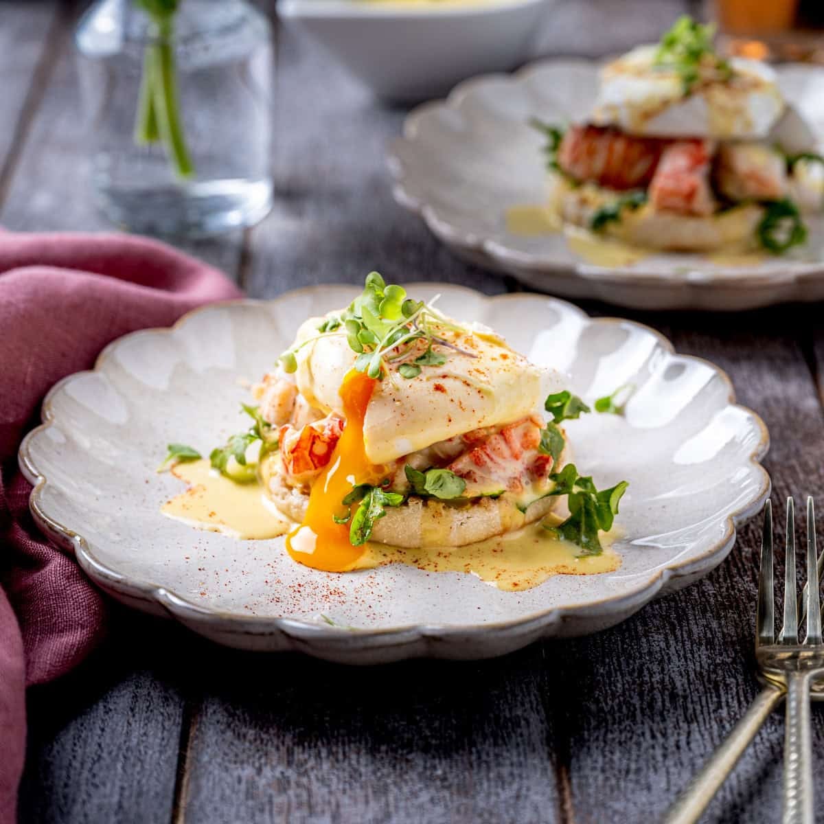 A closeup plate of finished Lobster Eggs Benedict with Saffron Cream Sauce