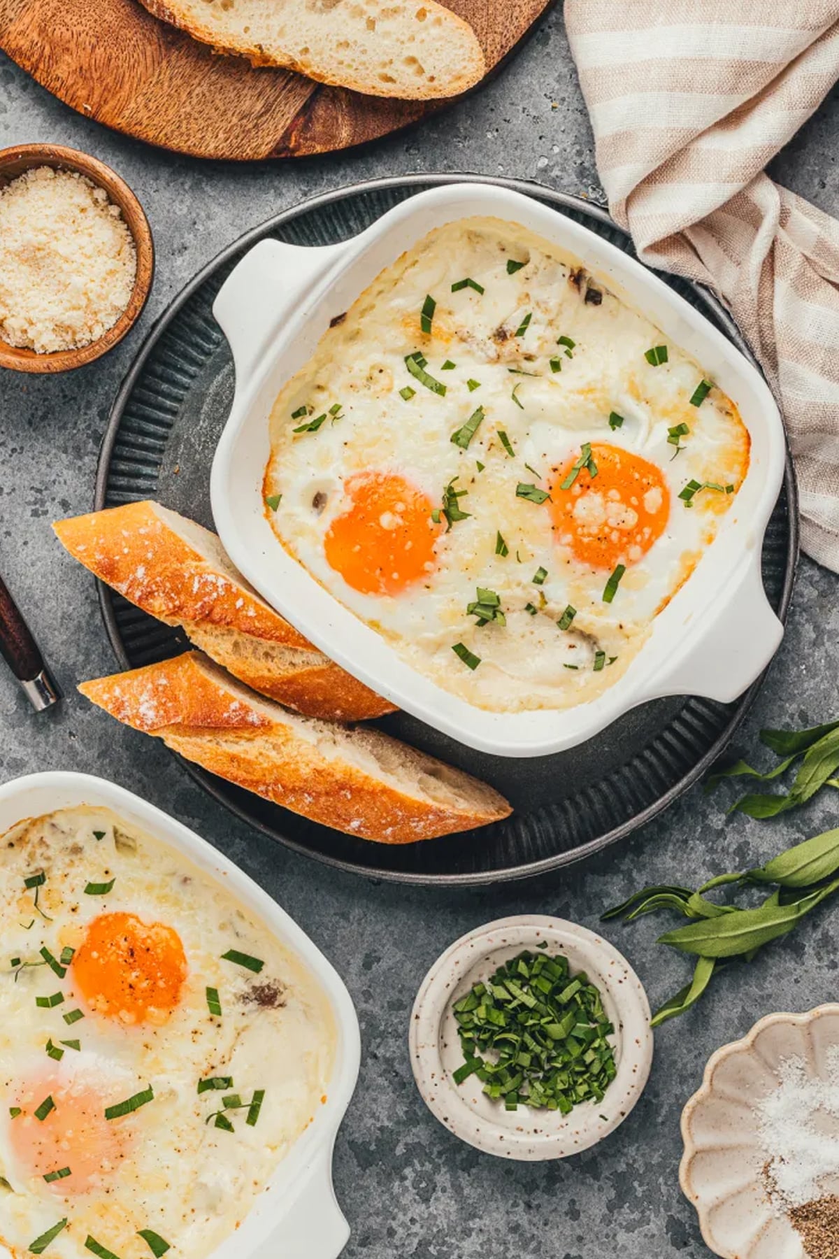 top down view of a finished dish of shirred eggs, slices of bread next to the dish
