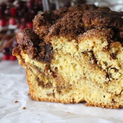 A close up of a slice of homemade cinnamon swirl bread in a piece of parchment paper