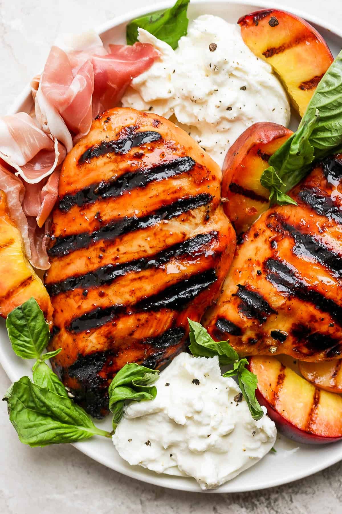 Grilled Peaches and Chicken on a white plate with mint garnish