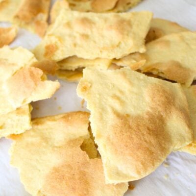 Broken pieces of homemade unleavened bread on parchment paper, ready to use for communion bread or as a snack.
