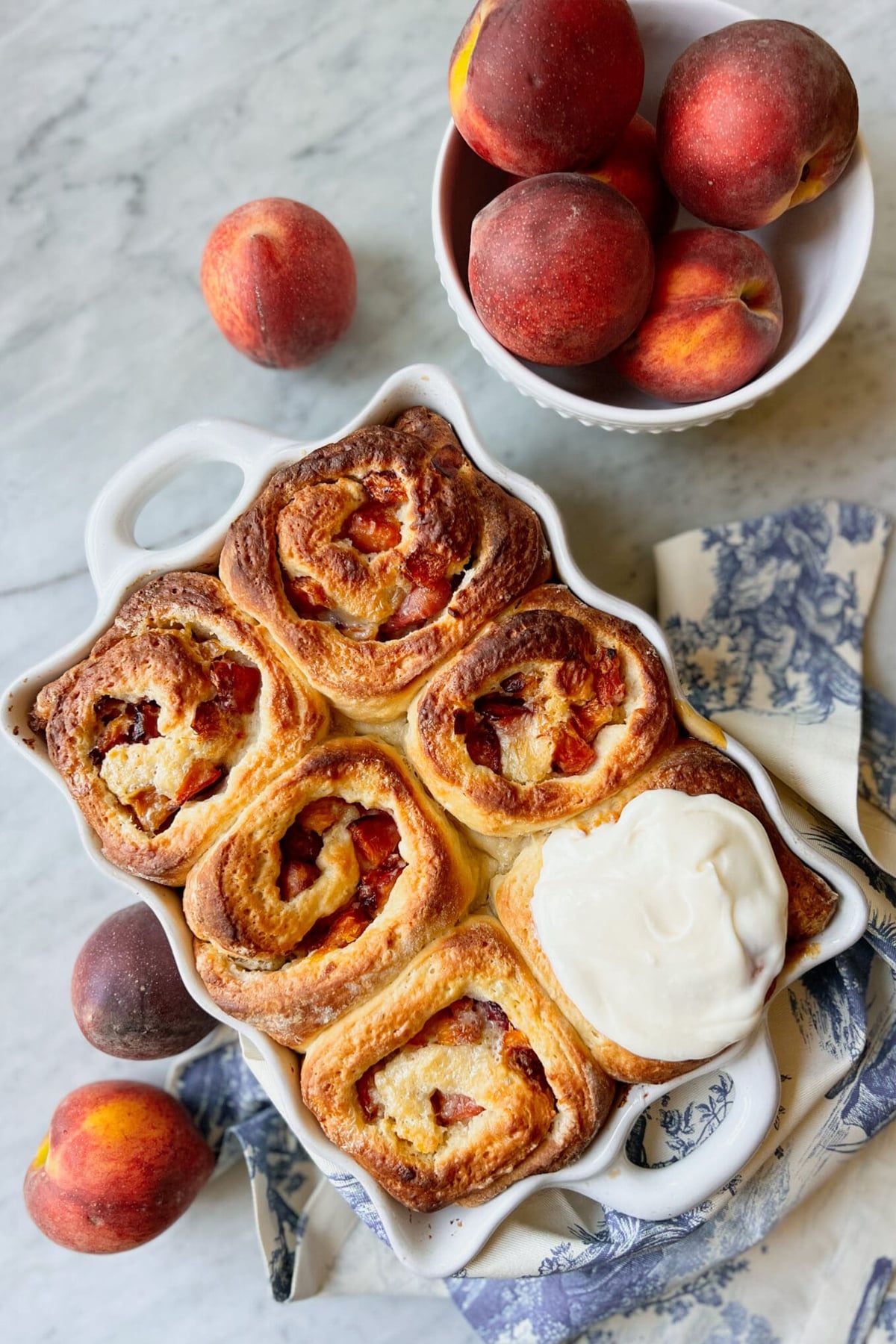 top down view of Peach Cobbler Rolls in a white baking dish