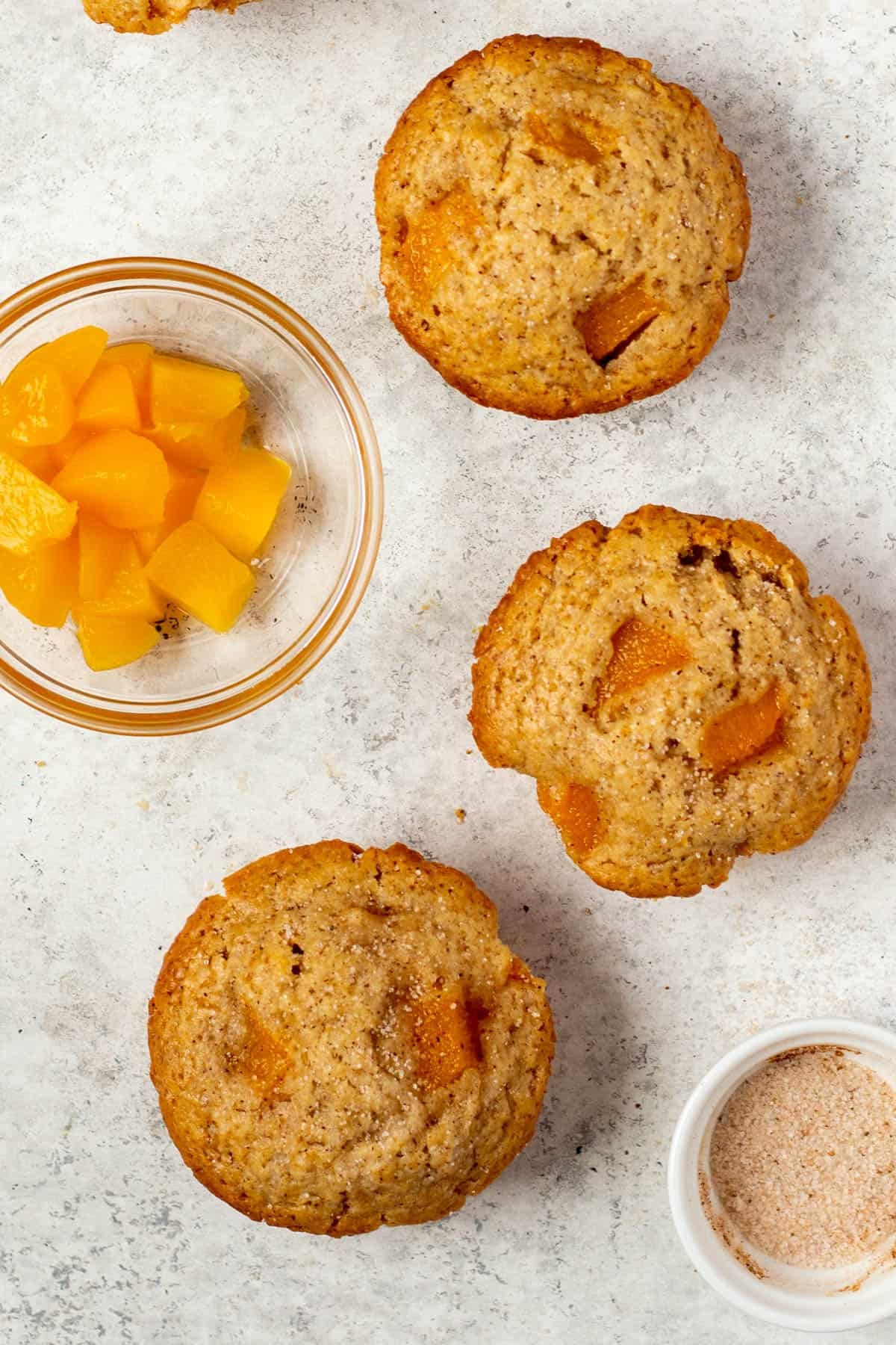 top down view of Peach Muffins on a marble counter