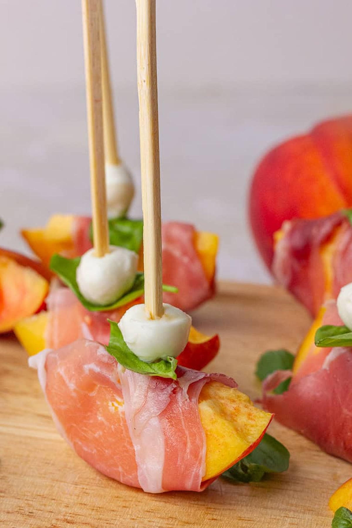 Peach Prosciutto Skewers on a wooden cutting board