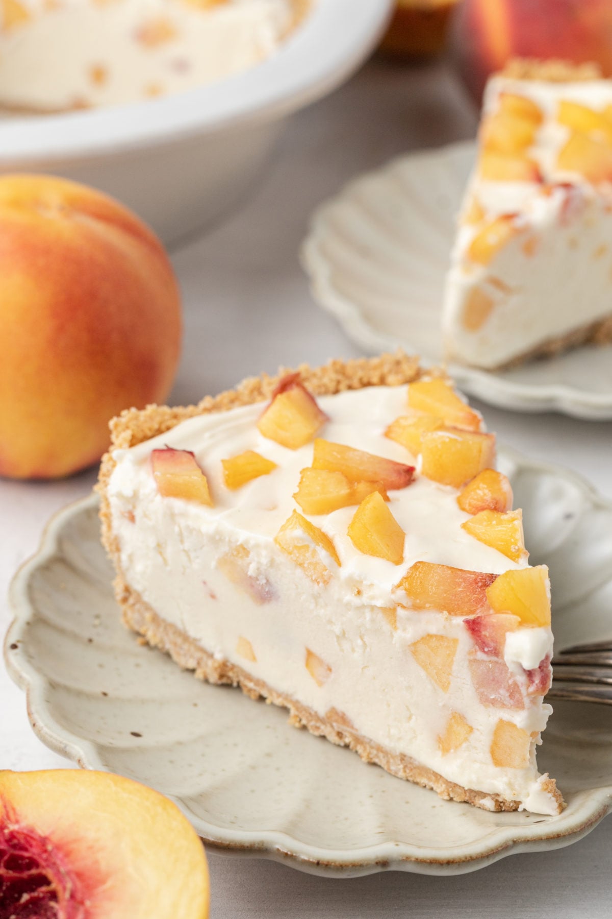 Peaches and Cream Cheesecake slice on a cream scalloped plate