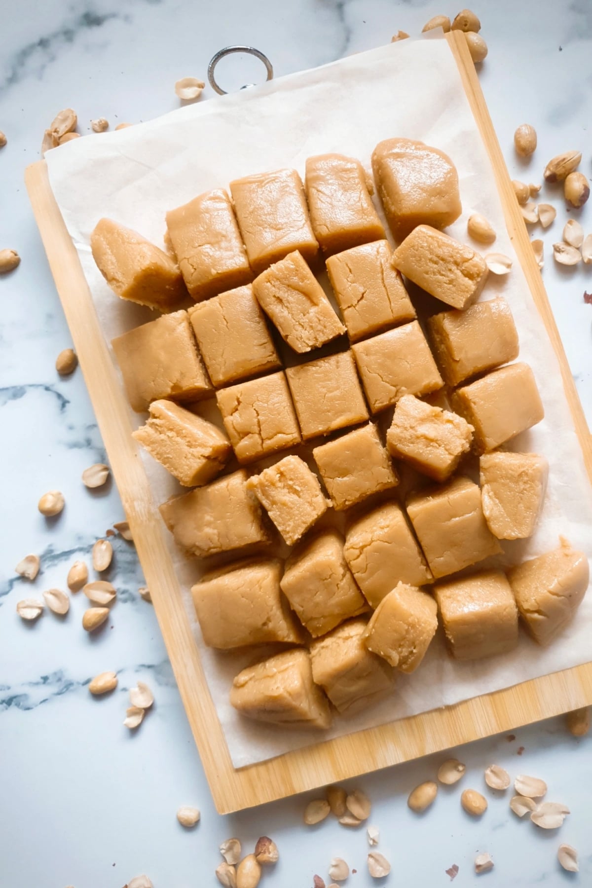 a large batch of Peanut Butter Fudge sliced on a wooden cutting board