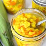 small-batch sweet corn relish in canning jars, one is opened to see the relish
