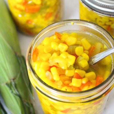 small-batch sweet corn relish in canning jars, one is opened to see the relish