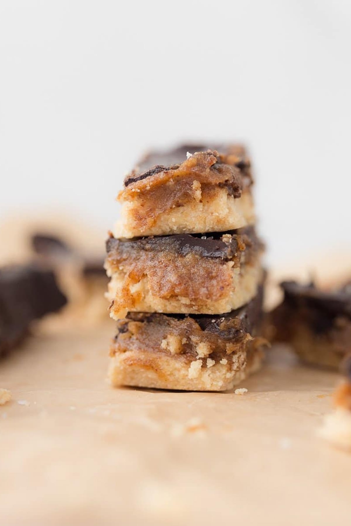 Homemade twix bars stacked on a piece of parchment paper