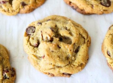 a stack of freshly baked homemade chocolate chip cookies on a parchment lined baking sheet