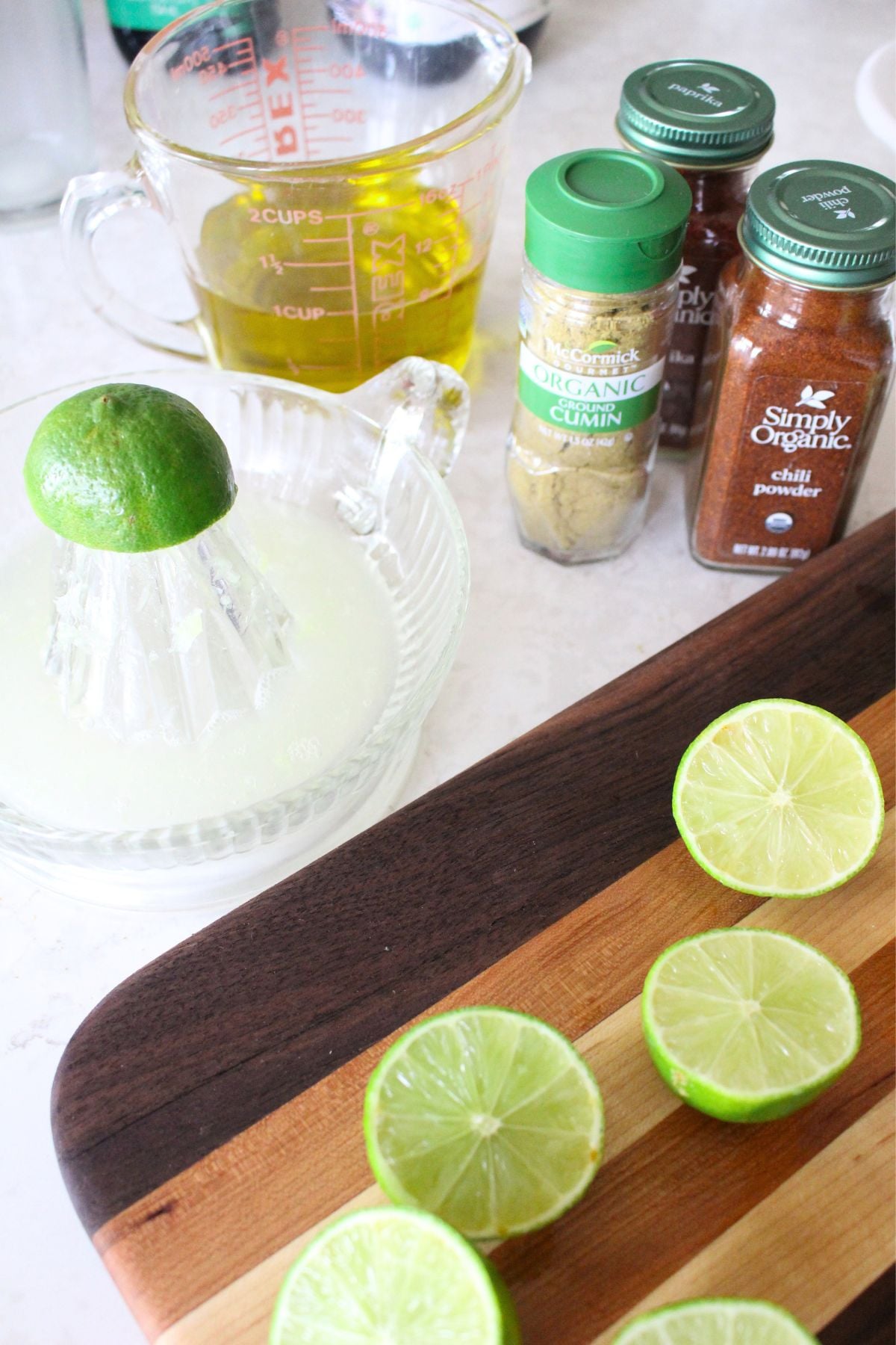 Ingredients for chicken fajita marinade on a white counter, with a mixing bowl