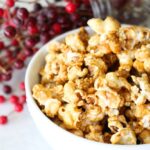 close-up image of a bowl of finished homemade caramel popcorn in a white bowl