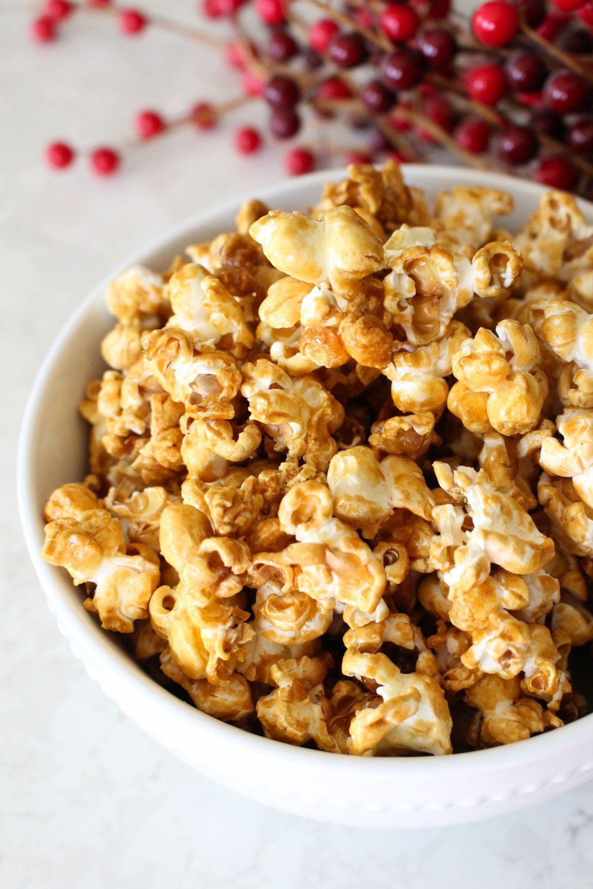 close-up image of a bowl of finished homemade caramel popcorn in a white bowl