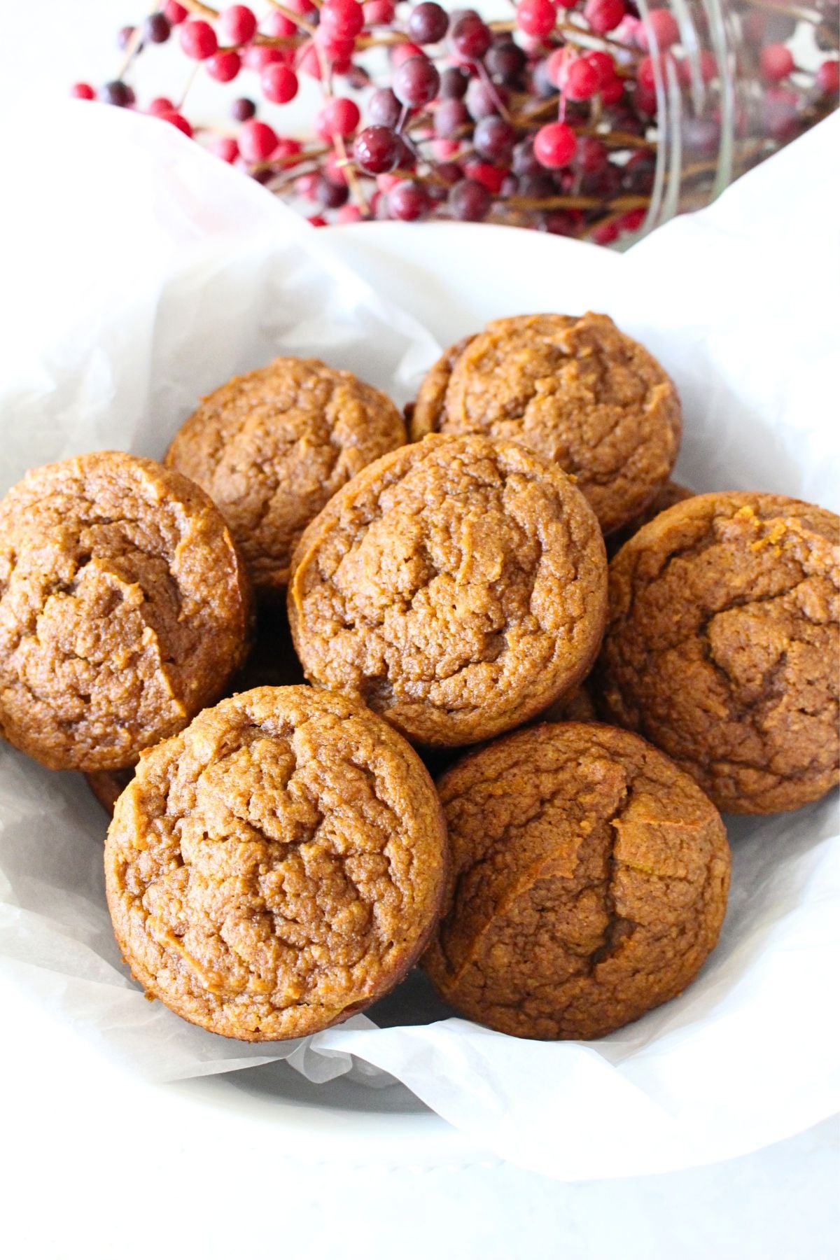 A serving bowl with finished pumpkin muffins filled to the top