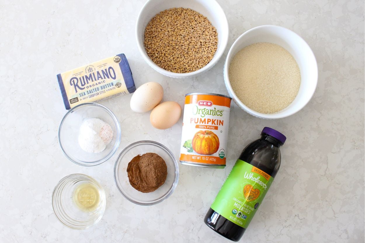 ingredients for homemade pumpkin muffins laid out of a white kitchen counter
